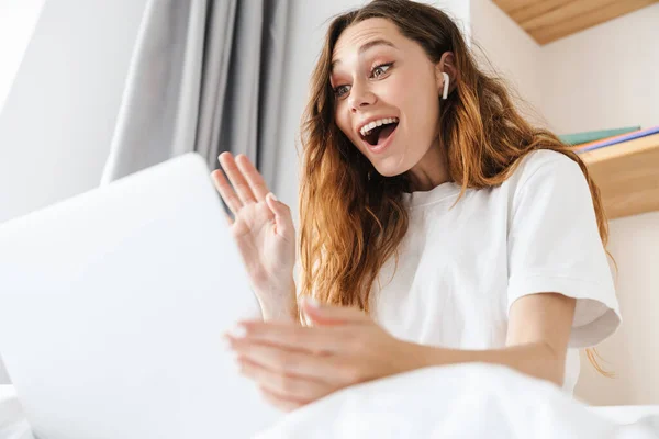 Portret Van Opgewonden Aantrekkelijke Vrouw Met Oortelefoon Zwaaiende Hand Terwijl — Stockfoto