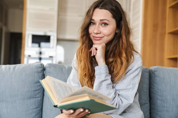 Foto Una Joven Alegre Sonriendo Leyendo Libro Mientras Está Sentada — Foto de Stock