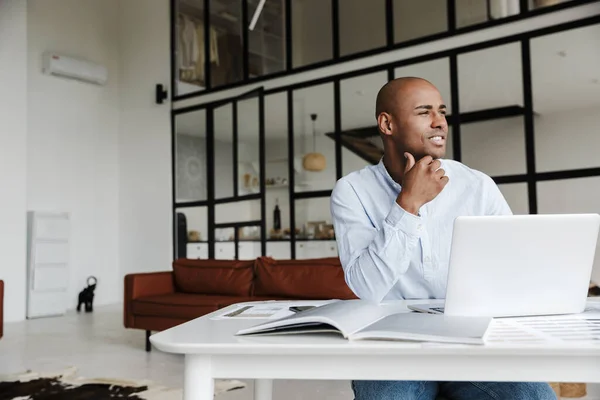 Foto Van Een Glimlachende Afrikaan Die Werkt Met Een Laptop — Stockfoto