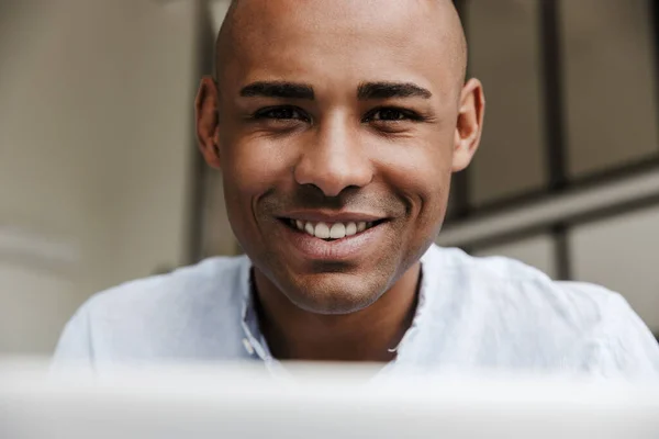 즐거운 아프리카계 미국인 남자가 노트북을 가지고 일하고 거실에서 미소짓는 클로즈업 — 스톡 사진