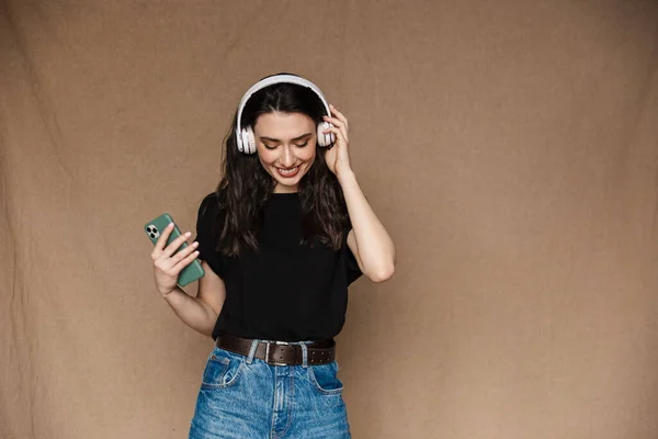 Foto Una Joven Morena Sonriendo Escuchando Música Con Auriculares Aislados —  Fotos de Stock