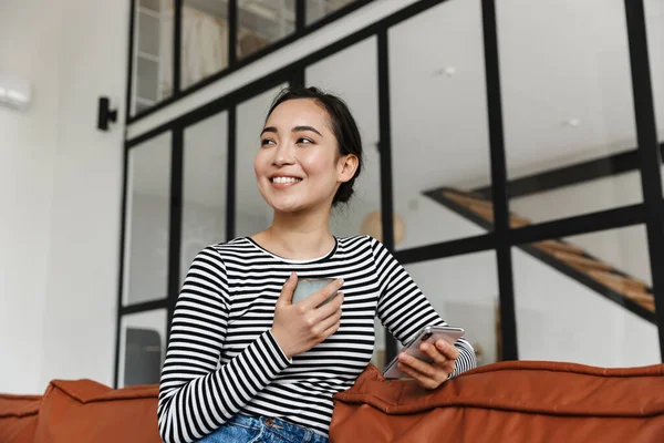 Attraktiv Leende Ung Asiatisk Kvinna Bär Casual Kläder Avkopplande Lädersoffa — Stockfoto