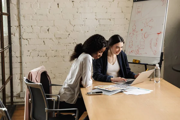 Modern bir ofiste yeni bir proje üzerinde çalışan iki çekici, gülümseyen, çok ırklı, zeki kadın girişimci.
