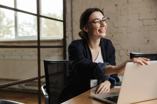 Confiante Sorrindo Atraente Jovem Empresária Trabalhando Computador Portátil Enquanto Sentado — Fotografia de Stock