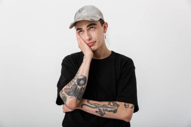 Kafası karışmış siyah elbiseli bir adamın portresi yukarı bakıyor ve beyaz arka planda başını destekliyor.