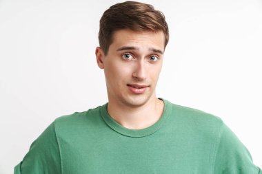 Beyaz arka planda izole edilmiş, beyaz tişörtlü, sinirli beyaz bir adamın görüntüsü.