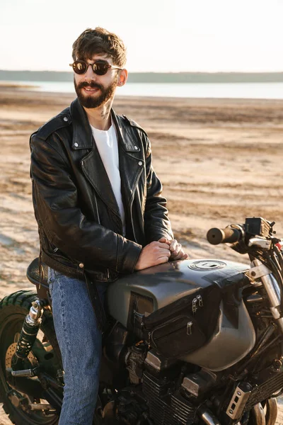 Красивий Усміхнений Молодий Бородатий Чоловік Шкіряній Куртці Сидить Мотоциклі Пляжі — стокове фото