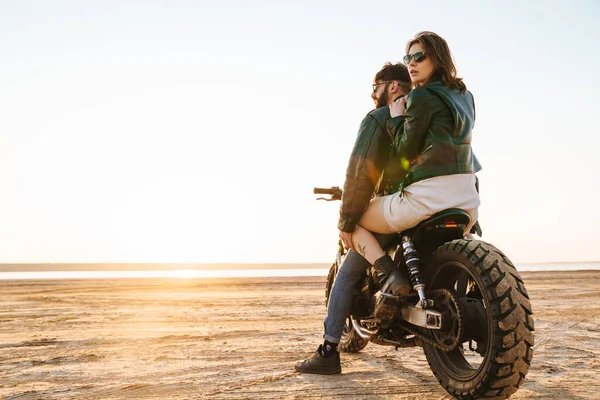 ビーチでバイクに乗って楽しむ美しい若いスタイリッシュなカップル — ストック写真