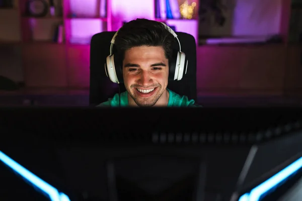 Изображение Белого Счастливого Человека Наушниках Играющего Видеоигру Компьютере Сидящего Столом — стоковое фото