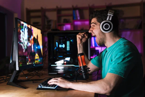 Imagem Jovem Animado Fones Ouvido Fazendo Gesto Vencedor Enquanto Joga — Fotografia de Stock