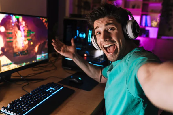 Kafkasyalı heyecanlı bir adamın evde bilgisayar oyunu oynarken selfie çekmesi