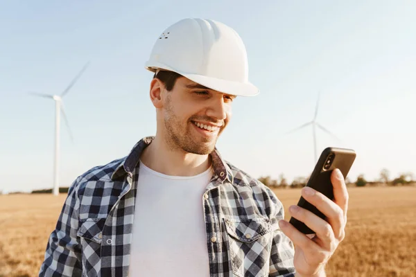 Elektrikli Yel Değirmeni Çiftliğinde Dururken Cep Telefonu Kullanan Gülümseyen Bir — Stok fotoğraf