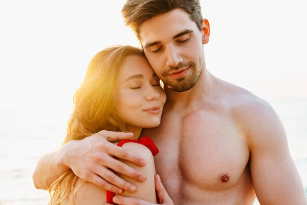 快乐的年轻夫妇在海滩拥抱 — 图库照片