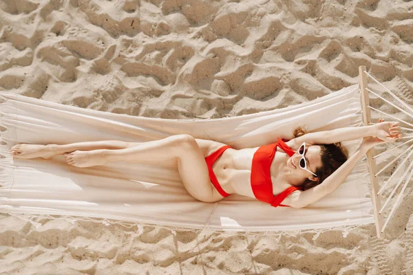 Sahilde hamakta uzanan mayo giymiş çekici bir genç kadının en güzel görüntüsü.