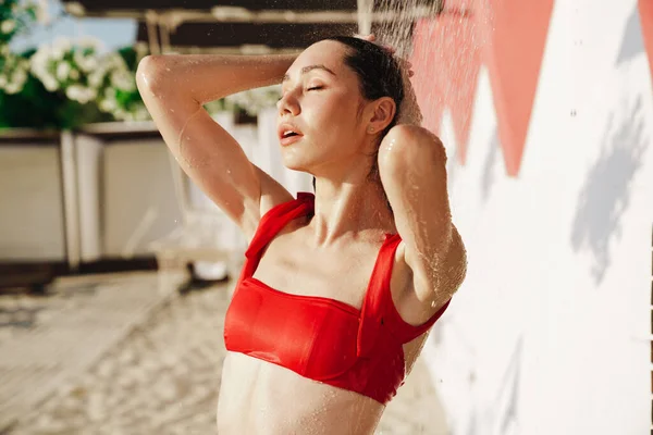 迷人的年轻女子穿着比基尼在海滩上洗澡 — 图库照片