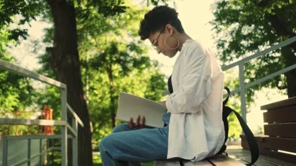 一位年轻漂亮的非洲裔美国妇女正坐在公园的长椅上看书 — 图库视频影像