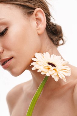 Beyaz arka planda izole edilmiş Alman çiçeğini tutan güzel, beyaz, beyaz, mutlu, üstsüz bir kadının görüntüsü.