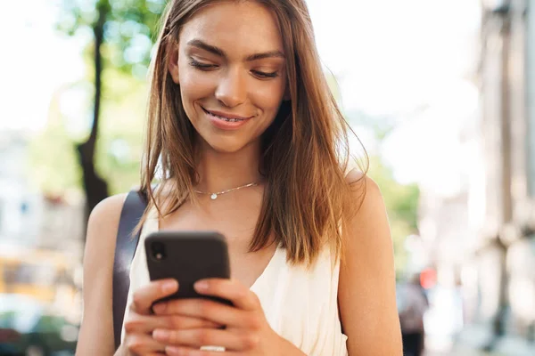 Egy Fiatal Mosolygós Gyönyörű Képe Amint Szabadban Sétál Mobiltelefon Használata — Stock Fotó