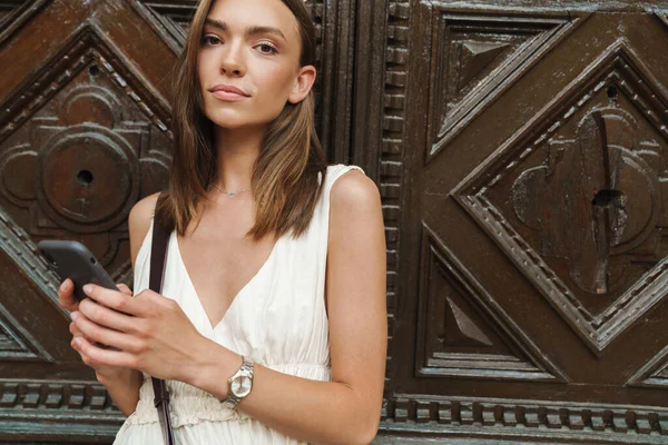 Photo Une Jeune Femme Concentrée Marchant Extérieur Tout Utilisant Téléphone — Photo