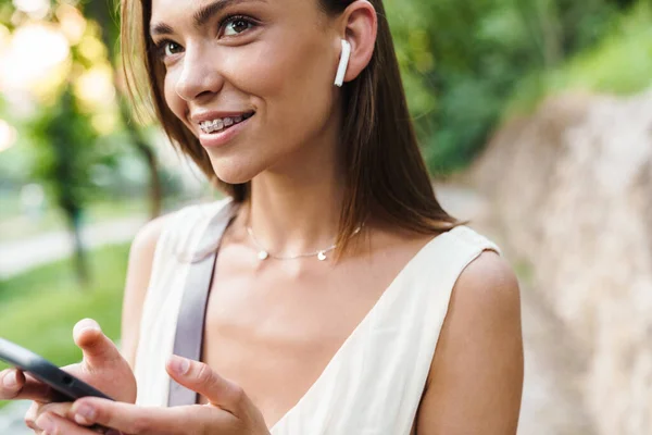 Imagem Jovem Mulher Morena Caucasiana Usando Fones Ouvido Sorrindo Segurando — Fotografia de Stock