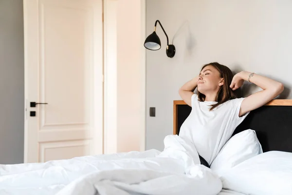 Sonriente Mujer Joven Atractiva Estirando Las Manos Por Mañana Cama — Foto de Stock