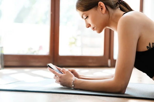 Přizpůsobit Mladé Sportovní Žena Pomocí Mobilního Telefonu Při Cvičení Fitness — Stock fotografie