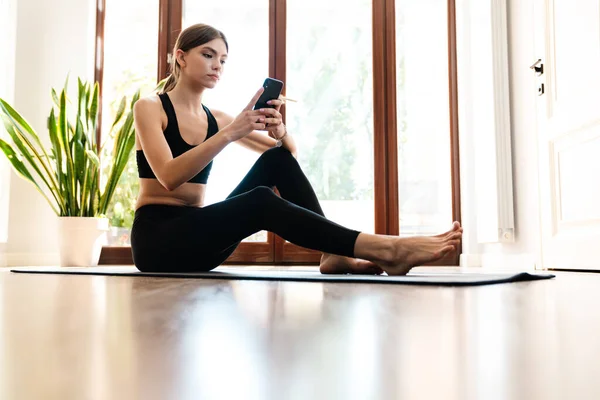 Přizpůsobit Mladé Sportovní Žena Pomocí Mobilního Telefonu Při Cvičení Fitness — Stock fotografie