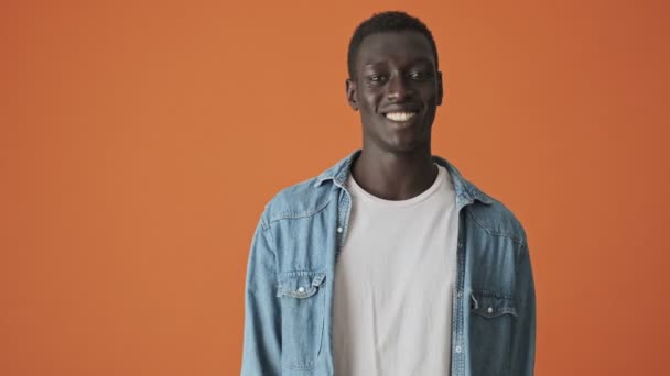 Положительный Африканский Молодой Человек Показывает Хороший Жест Оранжевом Фоне — стоковое видео