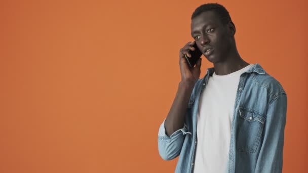 Jovem Afro Americano Bonito Está Falando Seu Smartphone Isolado Sobre — Vídeo de Stock