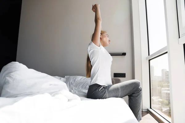 Photo Relaxed Young Woman Stretching Her Body While Sitting Bed — Stock Photo, Image