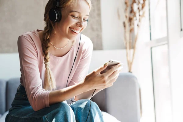 Foto Mujer Caucásica Alegre Usando Auriculares Teléfono Celular Mientras Está —  Fotos de Stock