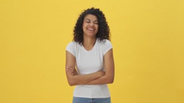 Genç, güzel, Afrikalı mutlu kadın. Sarı duvar arkasında izole edilmiş poz veriyor.