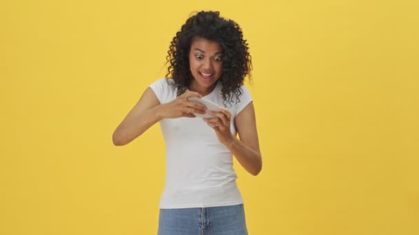 Joven Africana Emocional Mujer Jugando Juegos Por Teléfono Móvil Aislado — Vídeos de Stock