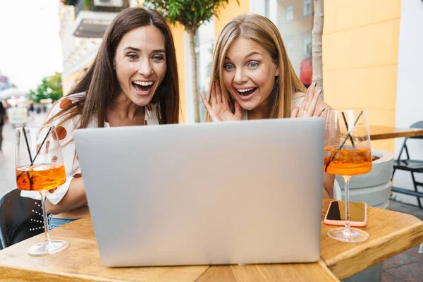 Imagen Dos Mujeres Adultas Encantadas Expresando Sorpresa Mientras Usan Portátil —  Fotos de Stock