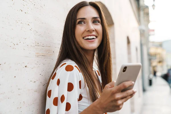 Beeld Van Gelukkig Brunette Vrouw Glimlachen Met Behulp Van Mobiele — Stockfoto