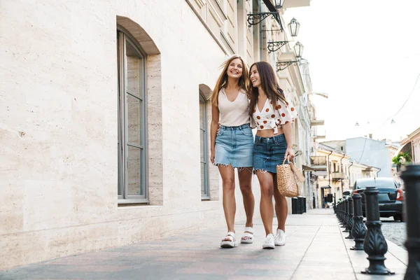 图为两个快乐的成年女子在街上散步时拥抱和欢笑的情景 — 图库照片