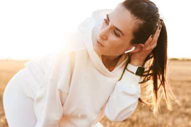 Kulaklıklı yetişkin bir sporcunun Altın Saha 'da çalışırken dinlenmesi.