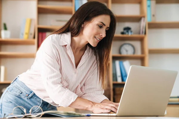 Kép Boldog Felnőtt Üzletasszony Mosolyog Miközben Dolgozik Laptop Asztalnál Irodában — Stock Fotó