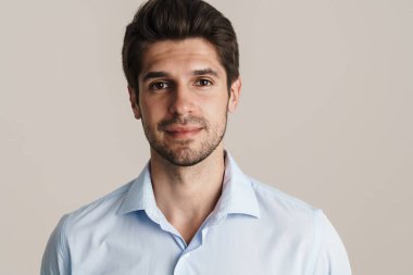 Mutlu iş adamı görüntüsü esmer adam bej arka planda tek başına dikilirken sana bakıyor