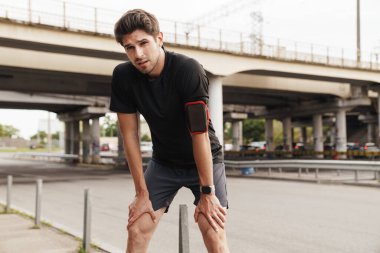 Şehir sokaklarında spor yaparken, akıllı telefonlu ve akıllı seğirmeli genç sporcunun görüntüsü