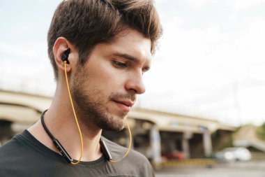 Atletik Kafkas sporcusunun şehir sokaklarında çalışırken kulaklık kullanması