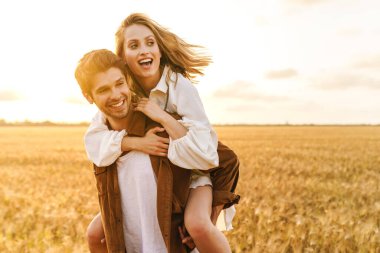 Kafkasyalı güzel bir çiftin kırsaldaki altın tarlada sırtına binişi.