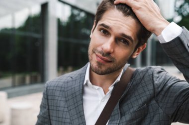 İş merkezinin yakınındaki açık havada iyimser yakışıklı iş adamının görüntüsü