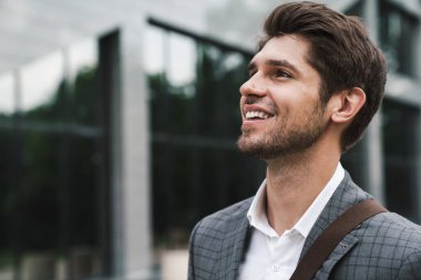 İş merkezinin yakınındaki açık havada mutlu ve iyimser bir iş adamının görüntüsü.