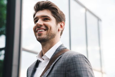 İş merkezinin yakınındaki açık havada mutlu ve iyimser bir iş adamının görüntüsü.