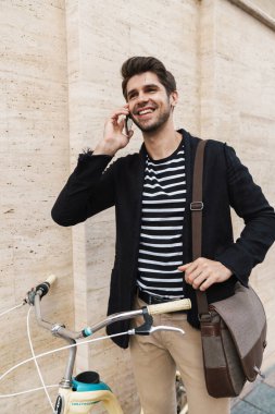 Dışarıda bisikletle konuşan neşeli bir iş adamının görüntüsü.