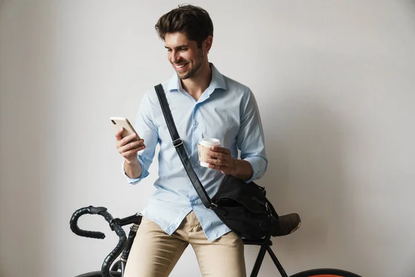 Wizerunek Szczęśliwego Biznesmena Trzymającego Filiżankę Kawy Komórkę Podczas Stania Rowerze — Zdjęcie stockowe