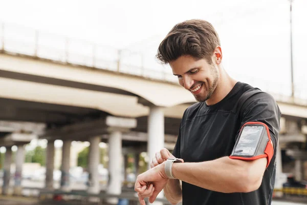 Imagem Atlético Sorrindo Desportista Com Smartphone Usando Smartwatch Enquanto Trabalhava — Fotografia de Stock