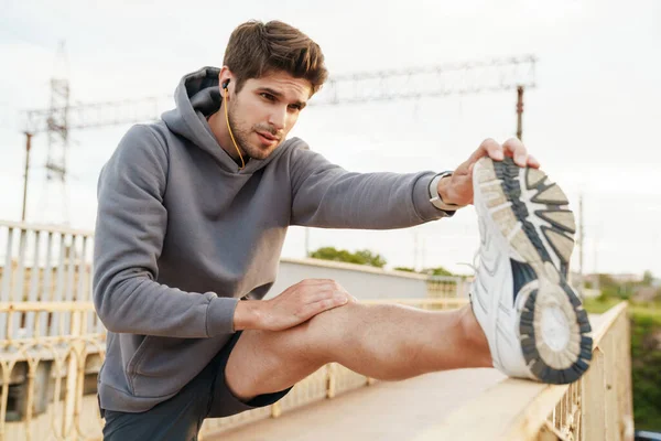 Imagem Jovem Esportista Caucasiano Fones Ouvido Fazendo Exercício Enquanto Trabalhava — Fotografia de Stock