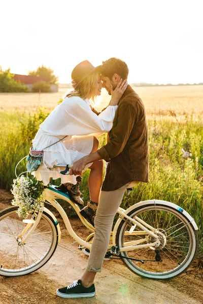 在乡村 年轻的高加索夫妇骑自行车接吻的照片 — 图库照片